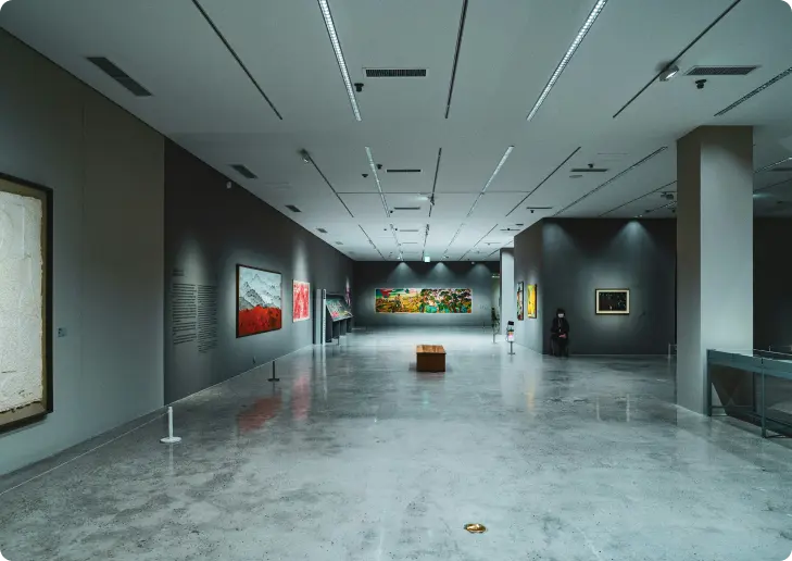 Spacious modern art gallery exhibition with polished concrete floors and contemporary art pieces on display